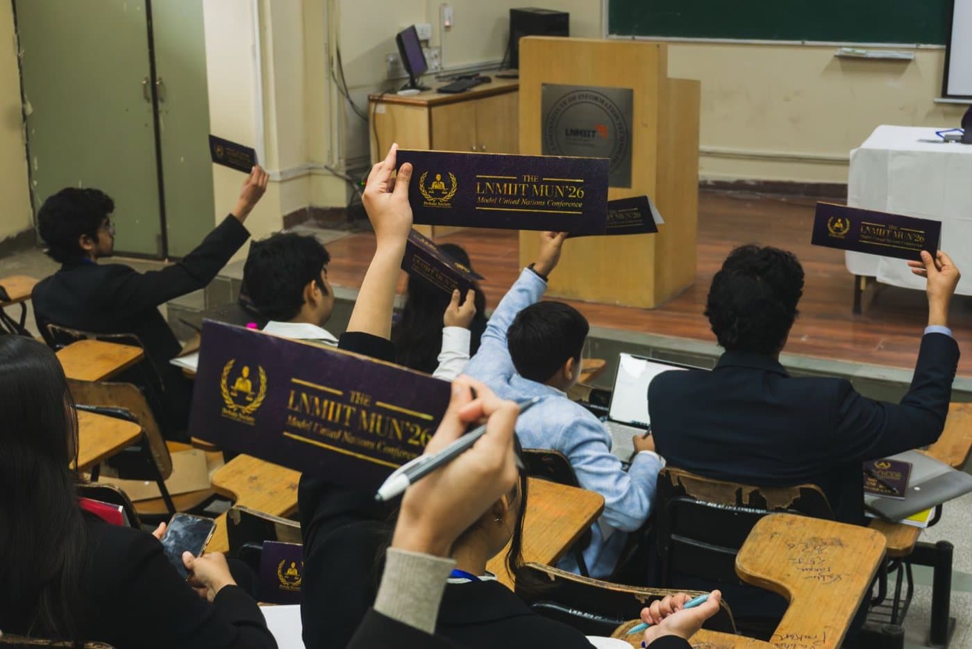 Delegates raising LNMIIT MUN'26 placards to vote in committee.